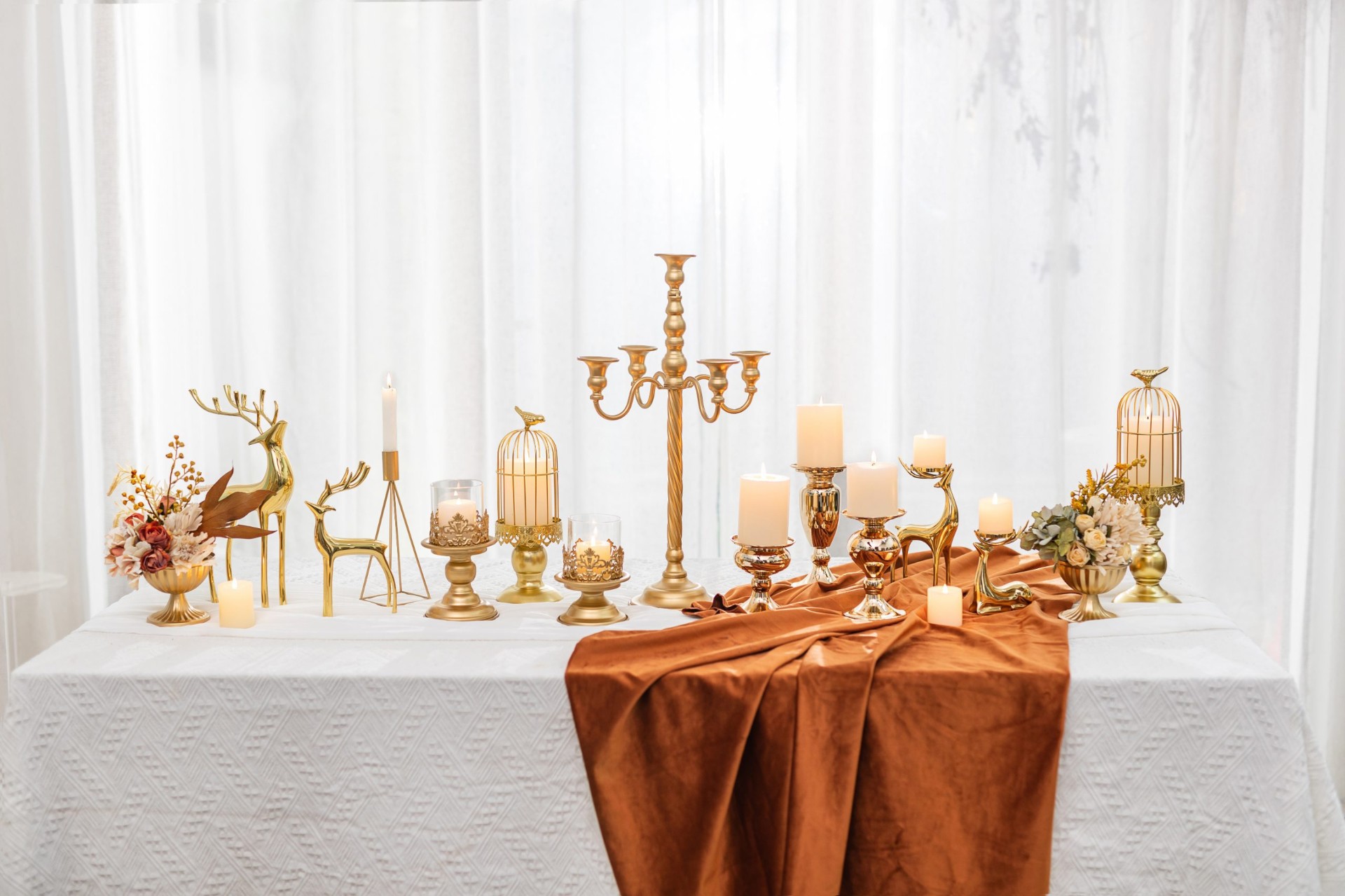 Curated gold candle holders and centerpieces on a styled table