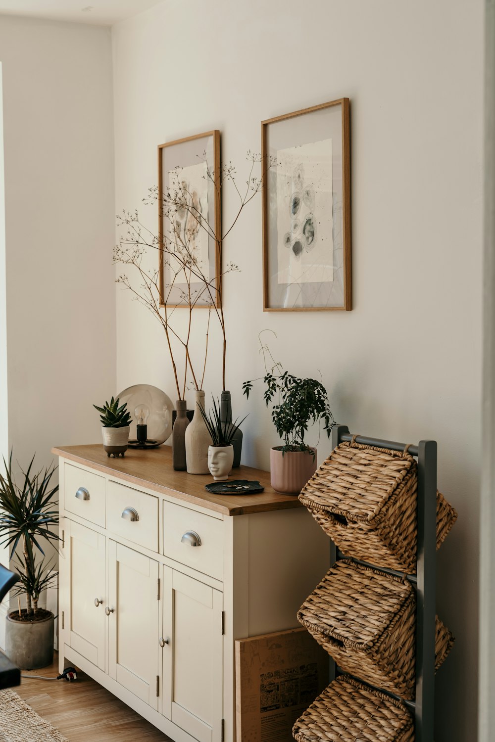 Stacked handwoven storage baskets styled beside a cream sideboard